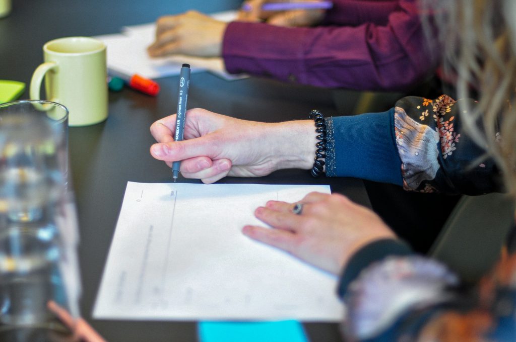 Adults collaborating over notes around a table