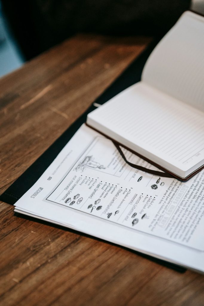 Open notebook and printed pages on a wooden table