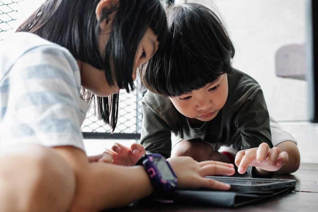 Two children using a tablet together at home