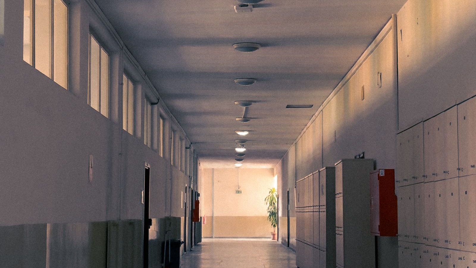 An empty school hallway with lockers and soft morning light.